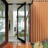 The Orcas Island house, whose steel exterior has patinaed to a rusty hue has a wide doorway with a pivoting door and a zero-step threshold.  Photo 2 of 8 in Architects Dream Up Truly Inviting Housing Options for Aging Population