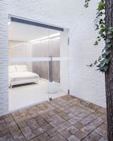 Outdoor, Small Patio, Porch, Deck, Wood Patio, Porch, Deck, and Back Yard A view of one of the bedrooms from a courtyard.  Search “future cities” from A Vision of the 'Apartment of the Future' From Poland