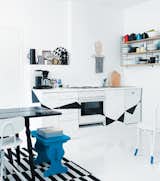 A Finnish family created a delightfully creative home on a DIY budget of just $4,000. Note the geometric pattern dancing across the cabinetry and the witty blue "socks" on the chair. (Pin)