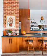 Woodwork in a warm hue and some ranch house flavor by way of brick make for one of the most inviting kitchens we've seen. Wood accents like pendants and barstools steer the kitchen firmly out of of Brady Bunch territory (not a trace of veneer here), but there is something just a little bit nostalgic about the vibe. Via The Design Files. (Pin)