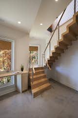 A window beside the centrally-located staircase looks out over the surrounding mountains.  Photo 7 of 10 in A Contemporary North Carolina Home Navigates a Tricky Site Atop a Ridge