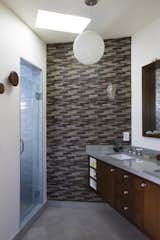 In one of the home's bathrooms, matching neutral tones prevent the abundance of stone and ceramic from feeling busy.