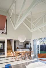 The inverted trusses subtly establish distinct spaces in the great room, with the bottom edges lending an intimate feel to the living area. A simple rice-paper lamp shade hangs above a kauri wood tabletop that the couple borrowed from Stock’s aunt and uncle and set on a set of Taurus legs from Nils Holger Moormann. A Brit Longue chair by Sintesi isat right.