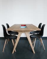 Paired with Eames side chairs, her dining table includes two cases “to either hide or show things,” she says.