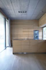 Kitchen and Wall Oven Oman and his partner Andrej Gregoric had the cupboards, stairs, and bed all custom-made. The interior casework provides storage and adds warmth to the concrete walls.  Photo 7 of 10 in Super Minimal Steel and Concrete Villa with an Unusual Facade