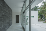A tumbled granite feature wall greets guests as they enter through the front of the house. The only enclosed area in the building lies behind the wall, separating the front entryway from the living areas.