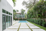 White stained, salt treated blocks of concrete were installed in a symmetrical pattern throughout the backyard area instead of a deck.