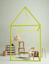 A neon green exposed frame houses various wooden furniture. In collaboration with Bettina Eulenburg for Better Living.