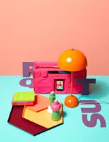 A collected bevy of brightly-colored objects such as HAY's Kaleido Trays lay smooth on a neon blue surface.