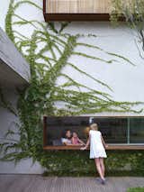 In São Paulo, Reinaldo and Piti Cóser kept green in mind when designing their deck. Here, Sophia Cóser talks to sister Helena and mother Piti through a wide, low-slung window typical of architect Marcio Kogan. Photo by: Crisobal Palma