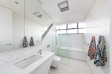 The kids’ bathroom is lined in clean white tile, which is arranged in a way that “responds to the twisting and folding externally,” Dunn says.