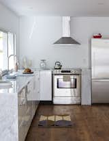 The updated kitchen is outfitted with stainless steel appliances, including a Bosch range, a Fisher & Paykel refrigerator, and a Frigidaire range hood. The faucet is Hudson Reed.  Photo 7 of 12 in Farmhouse by Mick from A Mind-Bending Renovation Brings a Bold, Modern Addition to an Old Farmhouse