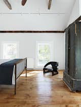 Kartell’s 4801 chair occupies a corner of the master bedroom.  Photo 12 of 22 in A Mind-Bending Renovation Brings a Bold, Modern Addition to an Old Farmhouse
