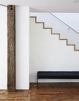 The modern staircase was built with the same salvaged wall planks that are used as flooring throughout.  Photo 20 of 22 in A Mind-Bending Renovation Brings a Bold, Modern Addition to an Old Farmhouse