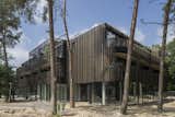 Located in a wooded the area, the facade camouflages the building into its surroundings.