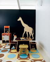A patterned giraffe wall decal sticks itself onto the deeply saturated blue hued wall in this modern playroom in Portland, Oregon. Photo by: John Clark. (Pin).  Photo 6 of 10 in Pinterest Board of the Day: Modern Design for Kids by Eujin Rhee