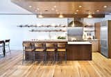 Recessed ceiling lights, speakers, and the range hood ductwork are all concealed by the dropped ceiling. The stools are West Elm.