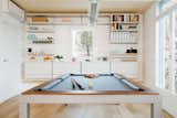 The dining room table transforms into a pool table for recreation.