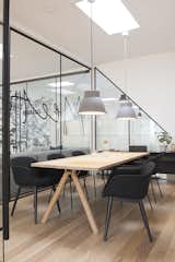 The subdued color scheme is also evident in the conference room. Floor-to-glass glass walls underscore the company's commitment to transparency, even in the most private spaces. The room is illuminated by grey Studio pendant lamps by Thomas Bernstrand.  Photo 6 of 7 in Muuto's Sophisticated Copenhagen Office is All About Transparency