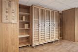 A wooden wardrobe provides storage, while a carved and burnt-wood board provides visual instructions explaining the room's possible configurations  Photo 5 of 6 in A Modular Meeting Room Features a Table with 6 Possible Layouts