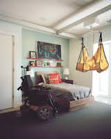In Matthew’s room, a Guldmann lift system joins a Hudson bed from Room & Board, while Atlas Industries bookshelves showcase personal treasures. Carpet by Bloomsburg, backed with rubber padding so the wheelchair doesn’t sink, is inlaid to prevent trip hazards.  Photo 7 of 8 in This Impressively Accessible Home Has a Tower That Can Be Reached by Wheelchair