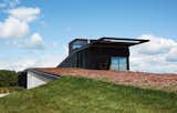 The house that architects Brian Johnsen and Sebastian Schmaling designed for Chele Isaac and John Neis appears to pop up from Wisconsin’s “driftless area,” an effect that is enhanced by a sedum roof that changes color with the seasons.