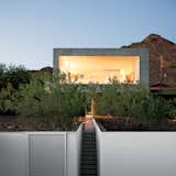 Exterior, Concrete Siding Material, and Flat RoofLine “The challenge was to render the site whole again after the original owner ‘bladed’ most of the creosote bush,” explains Debra Burnette, who concieved the landscape design.  Photo 2 of 4 in Giardino by Bianca L. Apse Trevisani from This House Doesn't Hold Back and Embraces the Desert