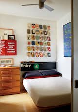 Kids Room and Bedroom Room Type Book jackets by Alvin Lustig and a vintage subway sign hang over a custom bed by Jeff Jenkins Design + Development.  Photo 8 of 12 in Bright Renovation of a Tiny Manhattan Apartment