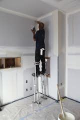A worker uses stilts to reach high areas while applying joint compound, also commonly referred to as mud. The mud workers are quite adept at walking around quickly while on stilts.  Photo 4 of 9 in Dwell Home Venice: Part 16