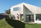 The architect behind this angular New Zealand home used surplus soil from the excavation to create a grassy berm, which acts as a natural fence.
