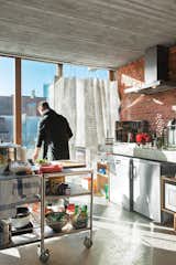 Kitchen ConfidentialFour years into his tenure at a former metal factory, revamped a decade ago by the architects BOB 361, architect Julien De Smedt is enjoying the pleasures of home. “I spend so much time in hotels and restaurants,” he says, “so I really like to cook when I’m here.” The founder and principal of 

JDS Architects splits his time between Brussels, Copenhagen, and New York, but finds himself more and more in his Belgian home.

In the open kitchen, De Smedt installed stainless steel rolling carts from Ikea to stand in as the kitchen island. “The carts are the kind of thing you find around the Bowery in New York at restaurant suppliers,” he says, “which I didn’t know at the time, or I would have had some shipped over.” De Smedt cribbed the idea from a friend in New York who had something similar in his kitchen. The polypropylene curtains are what the Swedish army uses for winter camouflage.