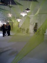 A massive, neon green Cat's Cradle in the Lasvit booth sets off the blown glass lighting to spectacular effect.