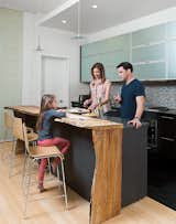David Alan Basche, Alysia Reiner, and their six-year-old daughter, Liv, chat in the kitchen, which is defined by a reclaimed spalted maple countertop crafted from a felled 100-year-old specimen sourced by The Hudson Company. The barstools are from Blu Dot.