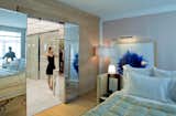 A guest room with a sliding tiled glass door leading to the luxurious bathroom.