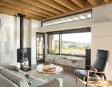 Living Room, Sofa, and Chair The living room is furnished with a Tolomeo Mega floor lamp by Artemide, a Milo Baughman Recliner 74, a Morsø 7648 wood stove, and a Hampton rug by Capel Rugs.  Photo 7 of 7 in An Artist Builds a Wooden Home That Lets Nature Be the Boss