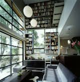 Hughes’ collection of hundreds of books is stored on a vertiginous two story bookcase, which takes up the whole of the northern wall of the living room. It’s an ingenious solution to the small-space dwelling that draws the eye up, adding texture and interest to the room without taking up floor space.