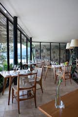 In the hotel's restaurant, floor to ceiling glass lets in plenty of natural light. The custom chairs have rope seats and backs.