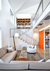 The house uses about half as much energy as a conventional residence in the area. Over the course of a year, it is projected to produce 2.6 megawatt-hours of energy while a comparable home will consume 13.3 megawatt-hours. "This offsets nearly 13,100 pounds of CO2 annually," Koenig says. "Plus, it uses renewable electricity to power driving."
To accomplish this level of energy savings, the architects designed a structure that would consume less. "We set out to build an extremely efficient envelope using passive design techniques, optimizing the house layout, windows, and insulation. Then we added extremely efficient heating, cooling and lighting systems, as well as appliances," Koenig says. "The passive design techniques resulted in an open space with tons of natural light. It’s a beautiful environment to spend time in." A Silva Giant LED floor lamp by Laguna Beach-based designers Cerno, Kristina sofa by Ekla Home, Loop coffee table by Arktura, area rug from Shaw, and end table from Iannone Design furnish the living room.