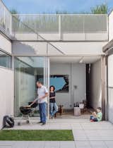 The home’s enclosed courtyard sits at “the heart of the structure,” says Baumann, who resides with his wife, Lisa Sardinas, and eight-year-old son, Oskar. “This is clearly the dominant space; everything flexes towards it.” Baumann cast the square concrete floor tiles himself, enlisting the help of his son. A small, neat patch of grass—a playful nod to the archetypal domestic lawn—is edited down to a charming folly.