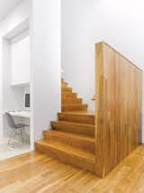 "We composed the house to have its highest, brightest space in the middle," says Paul Raff. Warm wood stairs lead to the second floor, which houses guest bedrooms, bath, and a kitchenette for the family's frequent visitors.