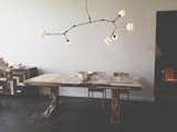 An elegant lighting fixture by NYC-based Lindsey Adelman hangs above a custom-made dining table by Piet Hein Eek.  Photo 4 of 6 in Beautifully Designed Retail Stores by Eujin Rhee from Design Shop We Love: The Future Perfect in SF