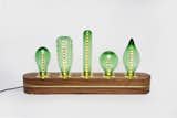 Available in both emerald and clear glass, the recycled bottle shelf lighting is stabilized by 10cm of hardwood.