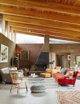 In the open-plan living and dining room, a dramatically sloped roofline allows for generous clerestory windows.