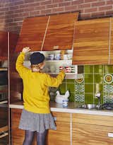 "The kitchen is pretty astonishing, really, considering it’s 40 years old," says resident Louise Jenkins. Large square tiles in green with sunflowers compliment the cabinets' natural wood finish.