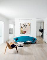 A MINIMALIST POP ART LIVING ROOM IN THE HOUSTON HEIGHTS

Vintage furniture like a turquoise curved sofa with an exposed wooden base, pair of mid-century polished stone-topped side tables from Houston's Reeves Antiques, and a sturdy wooden Pringle-chipped chair gather around the center, while a layered birch Pop Art wall piece by Mitch McGee gives the all-white living room a little more punch.

Photo by Jack Thompson.