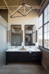 A SHY 04 pendant light from Bec Brittain adorns the master bath. The custom vanity is made from oak charred with Shou sugi ban. The fixtures are Grohe.  Search “big bang chandelier” from Industrial Loft in a Former Flour Mill