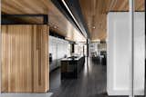 Cedar planks and gray-stained oak flooring line the interior. A minimalist LED lighting strip by Systemalux runs through the kitchen area, enhancing the wood ceiling’s reddish tone.