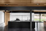 A dramatic black island is expertly balanced by a wall of white cabinetry and a refrigerator that blends perfectly. The kitchen’s black countertops were cut from Nero Assoluto granite. The sink and faucet are from Quebec-based company Rubi. Appliances are from Wolf.