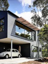 Exterior, House Building Type, Metal Siding Material, and Gable RoofLine Timber battens were used on north-facing windows to prevent excessive heat in the summer. The exterior is clad in Scyon’s Linea weatherboard and covered in Dylux’s Western Myall paint. Beneath the upper floor, a little nook makes for the perfect covered carport and storage spot for surfboards.  Photo 4 of 4 in House of the Week: Party in the Hills from A Breezy Modern Beach House Sits Among the Trees in Australia