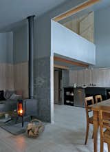 A wood-burning stove in the main room heats much of the house, including the mezzanine and the dining area.  Photo 5 of 12 in A Sliced-Up House Comes Together Again from Editor's Picks: 7 Inspiring Small Spaces
